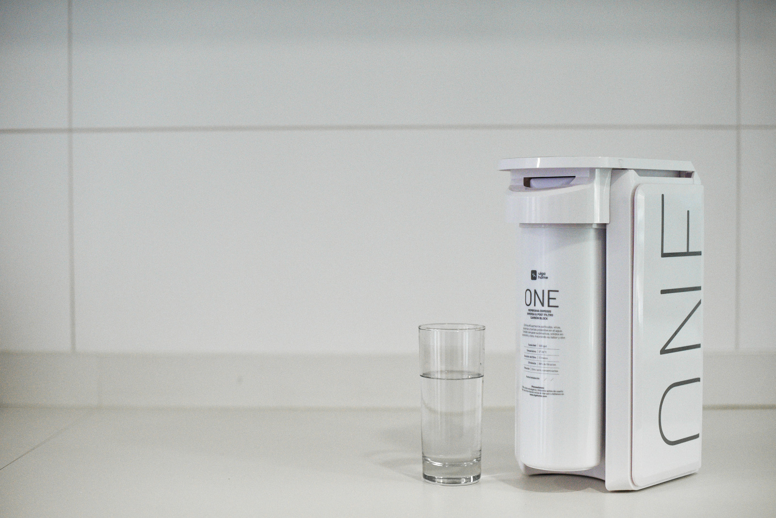 Equipo Osmosis junto a un vaso de agua filtrada limpia